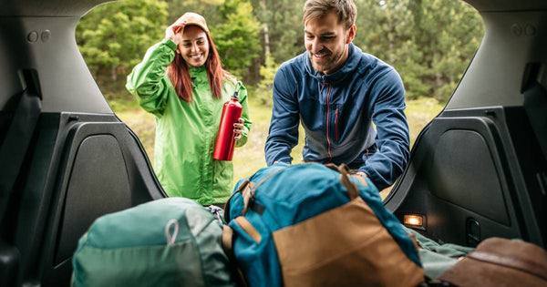 A couple packing a car for a camping trip