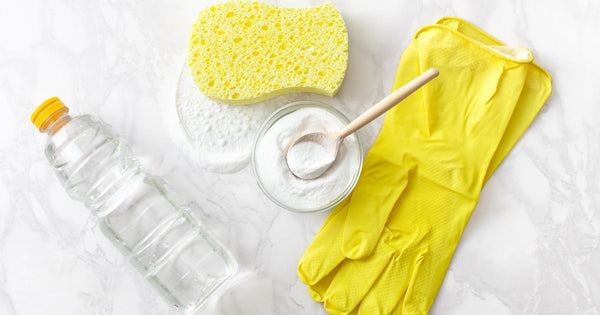 Cleaning supplies like baking soda, yellow gloves, and vinegar