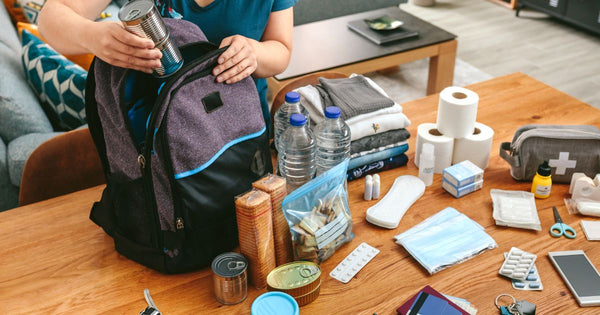 Person packing a road trip emergency kit