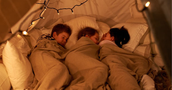 Three children sleeping in a tent